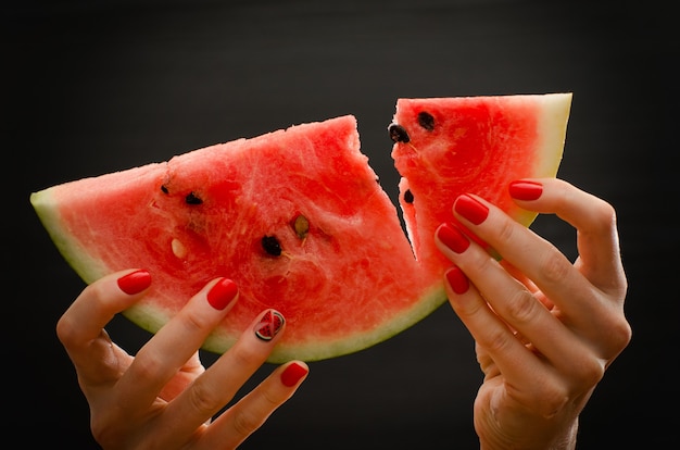 Broken big slice of ripe watermelon in female hands