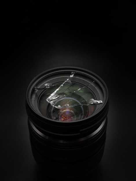 Broken black camera lens on a black background