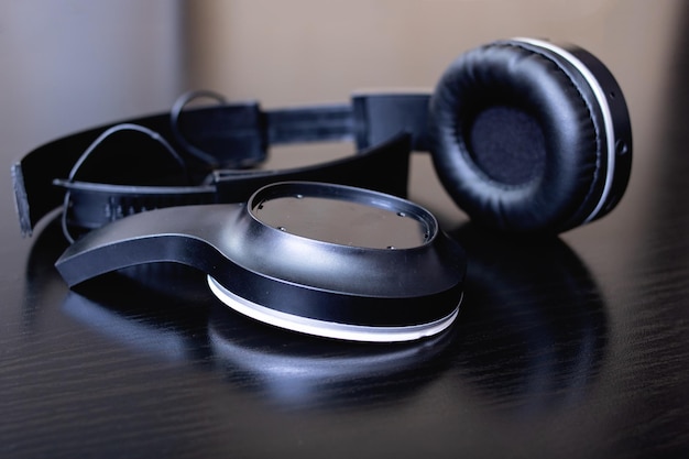 Broken black headphones on a wooden table