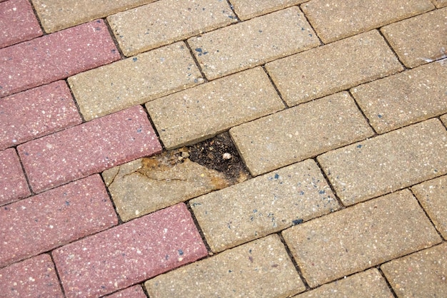 Broken brick in gray pavement close up