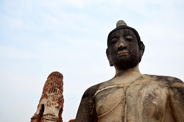 Foto statua di buddha rotta e antico edificio al wat mahathat ad ayutthaya thailandia