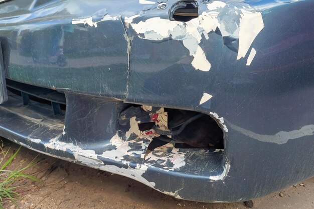 Broken bumper of car with peeling paint and hole in place of\
fog lamps accidents on roads and highways