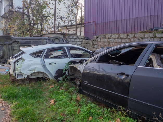 Разбитые машины возле автосервиса Автомобили на свалке Куча металлолома Бывший транспорт