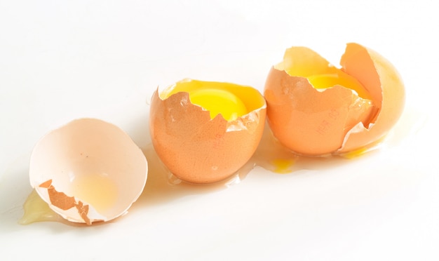 Broken chicken eggs isolated on white surface