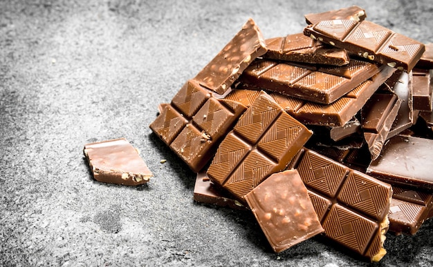 Broken chocolate bars. On a rustic background.