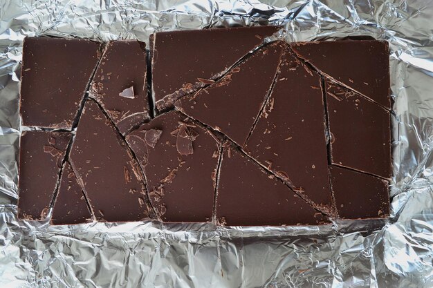 broken chocolate lies on foil