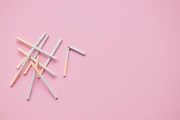 Broken cigarette on a pink background