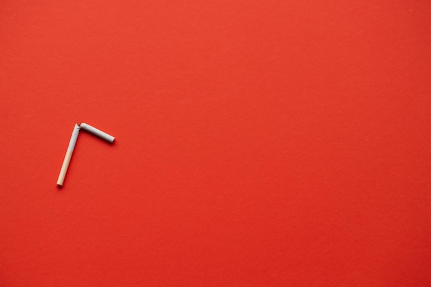 Broken cigarette on a red background No smoking concept