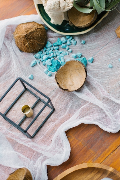 Broken coconut and blue sea decorative stones in the decor of the table. Sea or tropical holiday theme