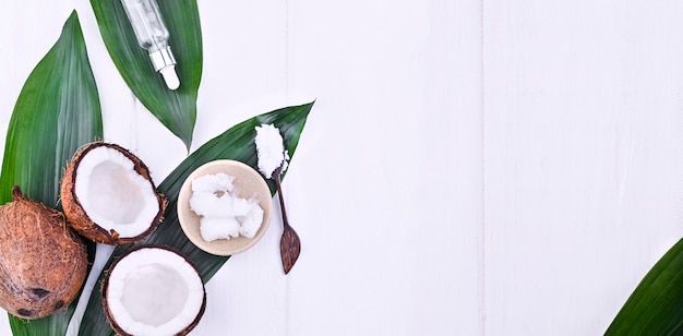 Broken coconut and butter. Exotic fruit on a white background. Free space for text. Copy space. Flat lay. Banner.