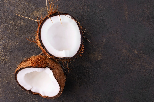 Primo piano rotto della noce di cocco con lo spazio della copia