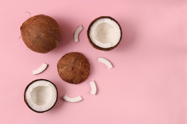 Broken coconut on a colored background top view