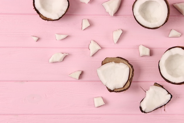 Broken coconut on a colored background top view