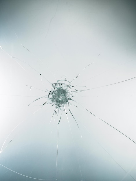 Broken cracked glass with hole over white background