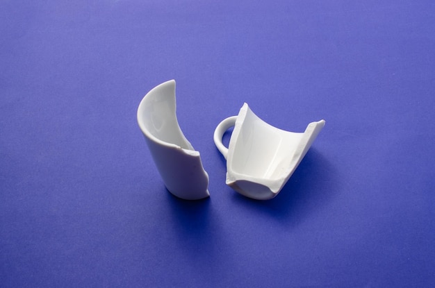 Broken cup broken glass parts crockery halves or broken white\
cup disintegration or accident and cut