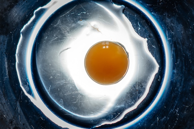 Broken egg in a blue plate. Abstract concept.