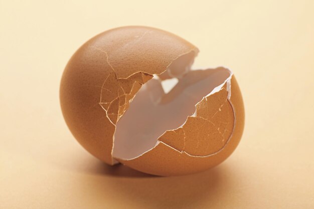 Photo broken egg on dark beige background