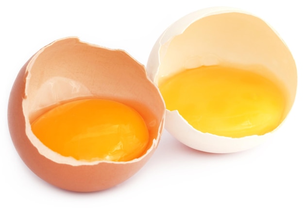 Broken eggs over white background