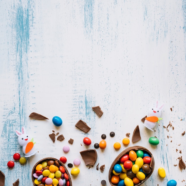 Photo broken eggs with candies near bunnies