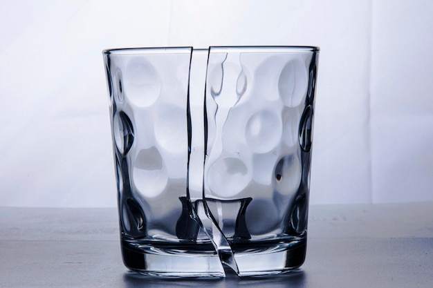 Foto vetro rotto in due metà con un cubetto di ghiaccio vetro rotto in due metà con un cubetto di ghiaccio
