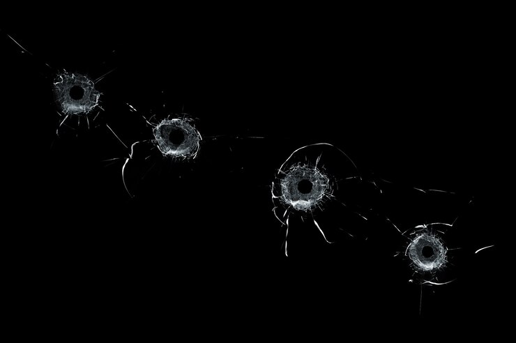 Photo broken glass multiple bullet holes in glass isolated on black