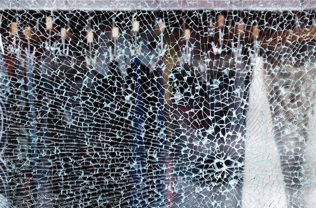 Broken glass of a shop window of a clothing store with unfocused background