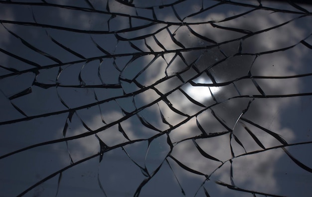 Broken glass over sky and sun behind the cloud background