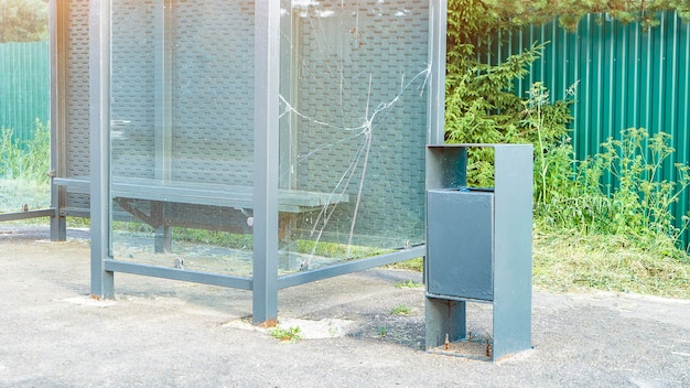 Parete di vetro rotta della fermata dell'autobus e del cestino della spazzatura nella foto premium del villaggio