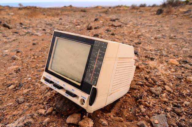 砂漠に捨てられた壊れた灰色のテレビ