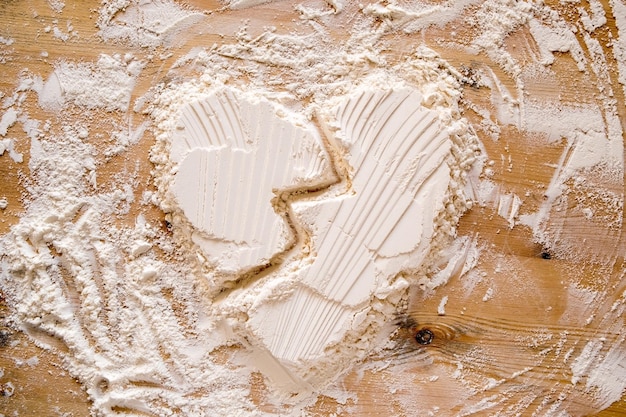 Broken heart is a symbol of love made from flour on wooden texture