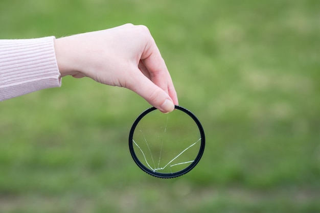 Broken lens filter in hand Cracked photofilter