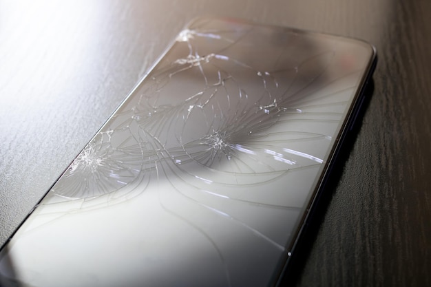 Broken mobile phone display cracks close up