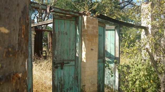 インドの村の田園地帯にある青いドアのある壊れた古い家