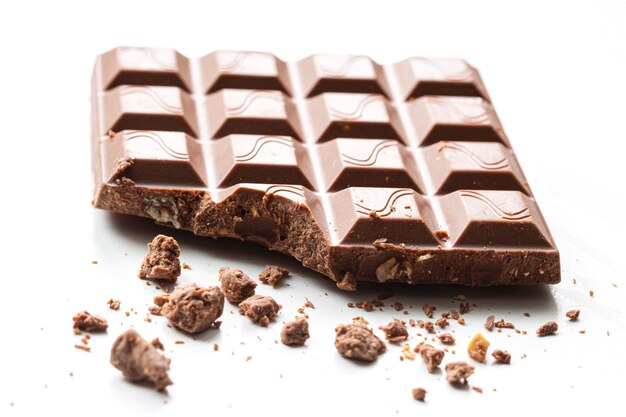 Broken piece of chocolate with crumbs on a white background Cocoa Dessert