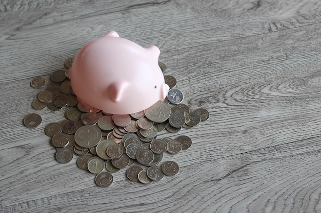 Broken piggy bank and coins on wooden table with copy space\
financial concept