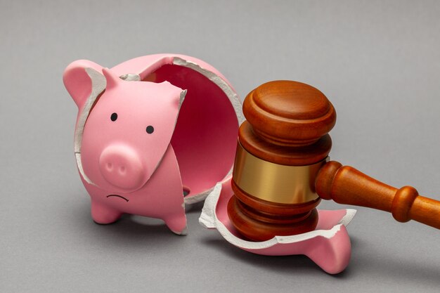 Broken piggy bank and judge gavel
 on gray background. Bankruptcy, crisis concept.