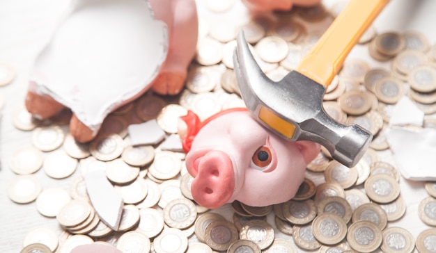 Broken piggy bank with coins on the white background.