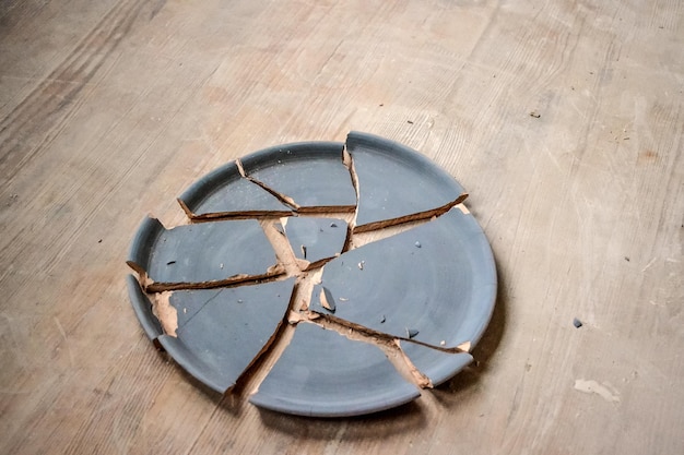 Photo broken plate lying on a wooden table