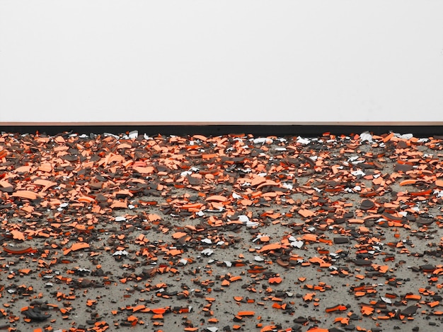 Фото Разбитые керамические изделия на дороге против стены