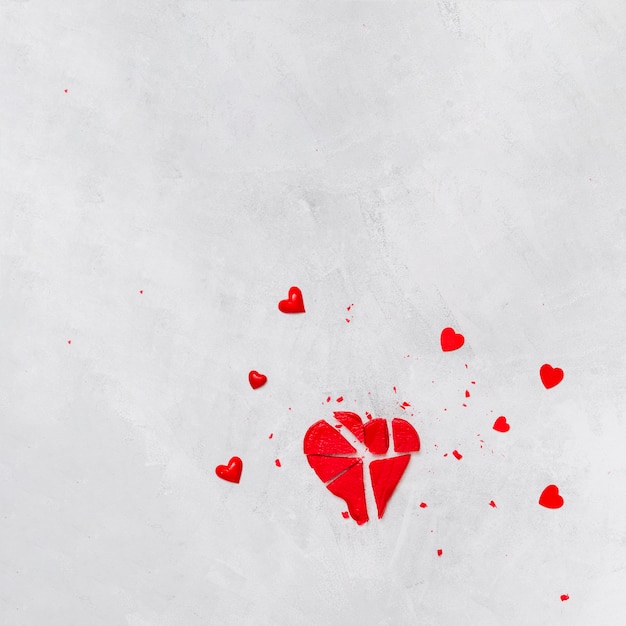 Broken red lollipop and decorative hearts 