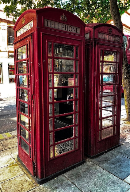 Foto cabine telefoniche rosse rotte.