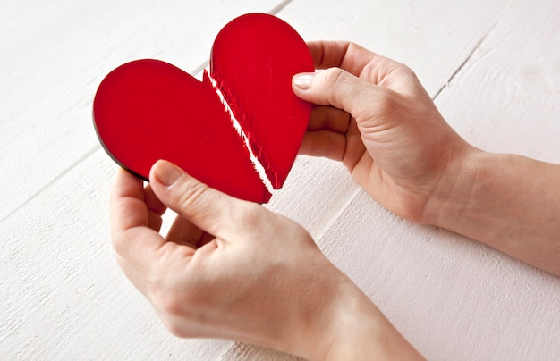 The broken red wooden heart in woman\'s hands