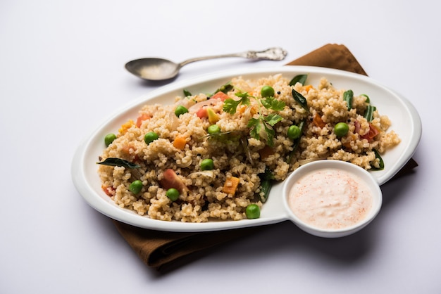 Broken wheat or Daliya Upma, served in a bowl. selective focus