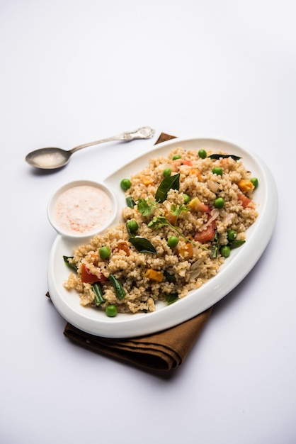 Broken wheat or Daliya Upma, served in a bowl. selective focus