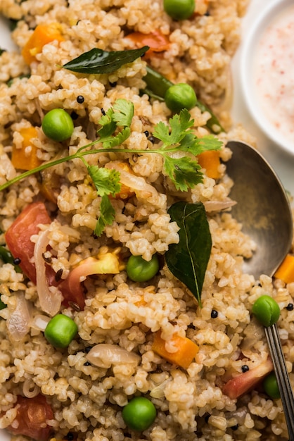 Broken wheat or Daliya Upma, served in a bowl. selective focus