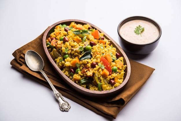 Broken wheat or Daliya Upma, served in a bowl. selective focus