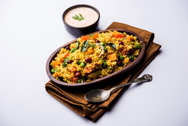 Broken wheat or Daliya Upma, served in a bowl. selective focus