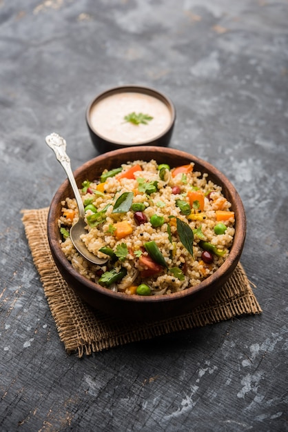 Broken wheat or Daliya Upma, served in a bowl. selective focus