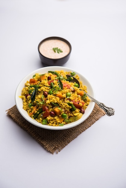 Broken wheat or Daliya Upma, served in a bowl. selective focus