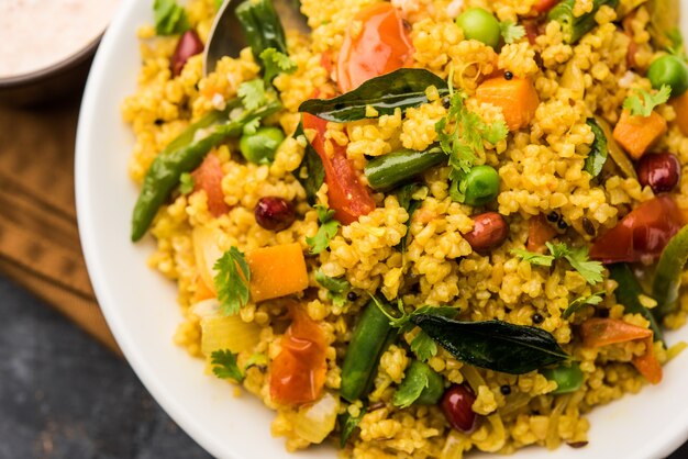 Broken wheat or Daliya Upma, served in a bowl. selective focus